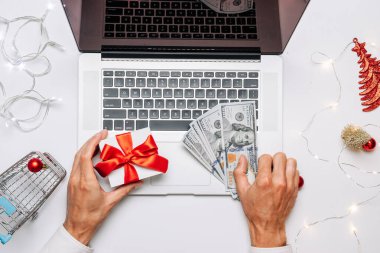 Çevrimiçi Noel. Hediye kutusu kırmızı kurdele, tramvay ve dizüstü bilgisayar, düz konumda internet alışveriş kompozisyonu. Kış Xmas tatil satışları