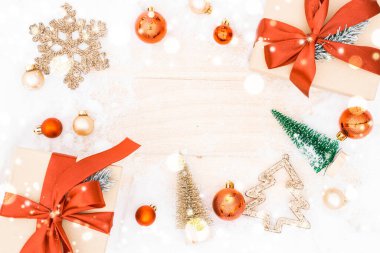 Kar ormanı. Kış ahşap dekorasyon geçmişi. Eski kırsal duvarlı bir Noel tahtası, beyaz donmuş kar tanesi, altın toplar ve hediye kutusu. Mutlu Noeller Noel kartı desenleri