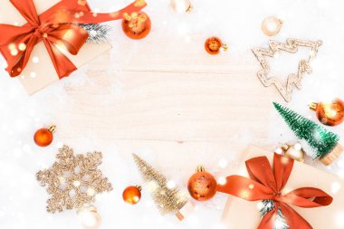 Kar ormanı. Kış ahşap dekorasyon geçmişi. Eski kırsal duvarlı bir Noel tahtası, beyaz donmuş kar tanesi, altın toplar ve hediye kutusu. Mutlu Noeller Noel kartı desenleri