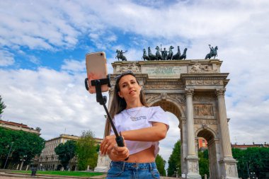 Blogger kızı Milan Italya. Piazza del Duomo 'da akıllı telefonlu gezgin fotoğrafçı kadın. Avrupa 'da Milano şehrinde boyama evi. Serbest çalışan, gazeteci, profesyonel fotoğrafçı..