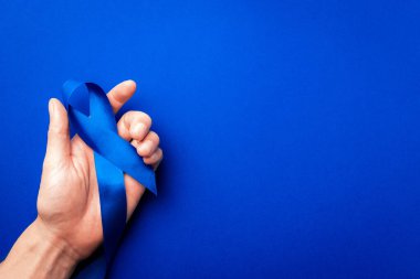 Prostat bakımı. Kasım ayında erkek sağlığının prostat kanseri olduğunun farkındalığı. Mavi kurdele, derin mavi arka planda izole edilmiş ellerde. Dünya Kanser Günü ve Dünya Diyabet Günü Konsepti
