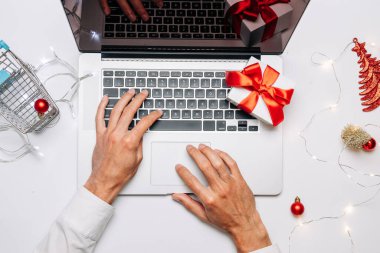 Xmas online alışveriş. Hediye kutusu kırmızı kurdele, tramvay ve dizüstü bilgisayar, düz bir internet alışveriş kompozisyonu. Noel mağazası, üst manzara.