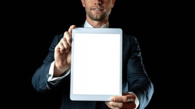 Ekran modeli. Boş tablet iş adamının elinde. Siyah afiş arka planında izole edilmiş akıllı ekran aygıtını düzenle. Oyun tasarımı, mobil uygulama sunumu veya portföy modellemeleri