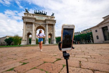 Milan İtalya medyasını etkilemek. Avrupa 'da Milano şehrinde boyama evi. Piazza del Duomo 'da akıllı telefonlu gezgin fotoğrafçı kız. Özgürlük, yaz seyahati, meslek kavramı