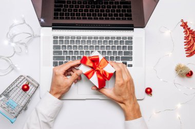 Xmas online alışveriş. Hediye kutusu kırmızı kurdele, tramvay ve dizüstü bilgisayar, düz bir internet alışveriş kompozisyonu. Noel mağazası, üst manzara.