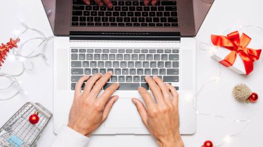 Noel indirimi. Hediye kutusu kırmızı kurdele, tramvay ve dizüstü bilgisayar internette online alışveriş kompozisyonu olarak yatıyordu. Hediye al, Noel 'e hazırlan, hediye kutuları ve paketler arasında.