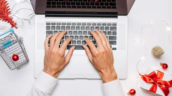 Tatil çevrimiçi alışveriş. Hediye kutusu kırmızı kurdele, tramvay ve dizüstü bilgisayar, düz konumda internet alışveriş kompozisyonu. Mutlu Noeller ve mutlu yıllar.