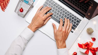 Çevrimiçi. Noel için hediye kutusu kırmızı kurdele, tramvay ve dizüstü bilgisayar, düz konumda internet alışveriş kompozisyonu. Noel satışları ve indirimler