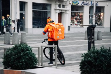 KATOWICE. POLAND - 26 Mart 2021: teslimat servisi için yemek çantası. Hızlı restoran teslimatı için bisikletli ya da motosikletli adam. Pyszne müşterilere hızlı mal sevkiyatı