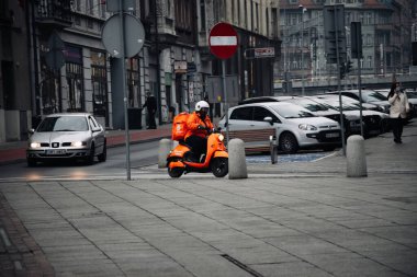 KATOWICE. POLAND - 26 Mart 2021: teslimat servisi için yemek çantası. Hızlı restoran teslimatı için bisikletli ya da motosikletli adam. Pyszne müşterilere hızlı mal sevkiyatı