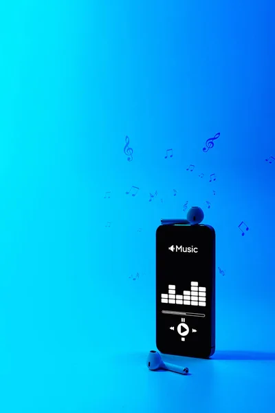音楽の背景 音楽アプリケーション サウンドヘッドフォンを搭載したモバイルスマートフォンの画面 ラジオのある音声は青のグラデーションで打ちます コピースペース付きのスタジオまたはポッドキャストバナーの録音 — ストック写真