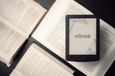 E-kitap okuyucu. Dijital kitap, kütüphane okuyucu tableti koyu arkaplanlı kitaplar. Eğitim kavramı, kütüphane, öğrenciler