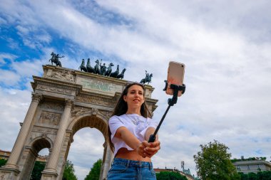 Gezginler Milan adasını etkiliyor. Avrupa 'da boyama evi Milano' da. Piazza del Duomo, Katedral Meydanı 'nda akıllı telefonlu fotoğrafçı kız. Seyahat ve serbest çalışma, modern yaşam tarzı.