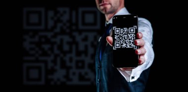 Qrcode 'u tara. Ödeme için akıllı telefon ekranında QR kod tarayıcısı olan dijital cep telefonu, online ödeme, barkod teknolojisi adamı tutuyor. Perakende mağazası dijital ödemeyi parasız kabul etti.