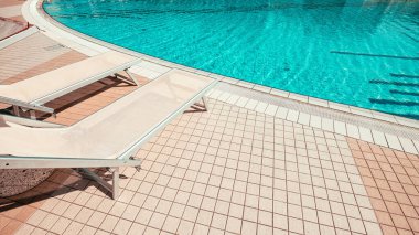 Güneş Salonu. Yaz tatili koltuğu, lüks otel havuzunda dinlenme salonu. Plaj şezlongu. Tatil yatağı. Mavi su, güneşli seyahat tatili