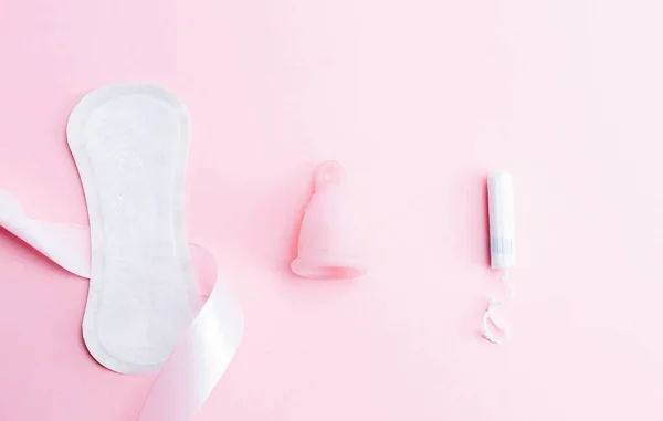 ピンクの背景に女性の衛生のための月経パッド 月経カップとタンポン 月経女性期 フラットレイアウトバナー テキスト用のスペースをコピーします 婦人科のケア — ストック写真