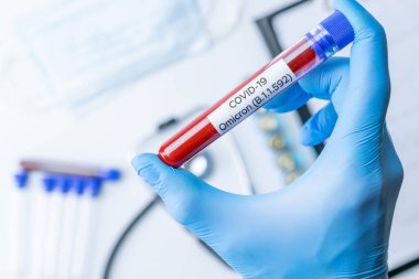 Omicron mutasyon koronavirüsü varyantı. Tıbbi laboratuvar doktoru hastane laboratuarında deney tüpü tutuyor. Pandemik önleme. Klinik araştırma