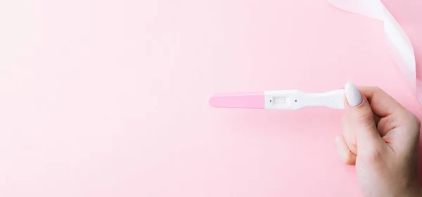 Graviditetstestutrustning Kvinnlig Hand Hålla Positiva Graviditetstest Med Sidenband Rosa Bakgrund — Stockfoto