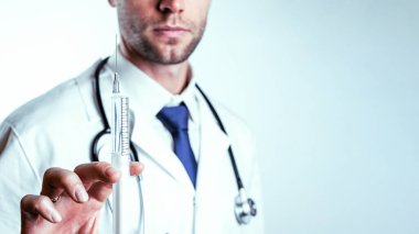 Şırınga iğnesi tıbbi enjeksiyon. Seçici odaklanma, doktorun elinde şırıngayla mavi eldiven tutması. Hastane beyaz doktor önlüğü, steteskop. Kopya alanı olan grip aşısı şırıngası