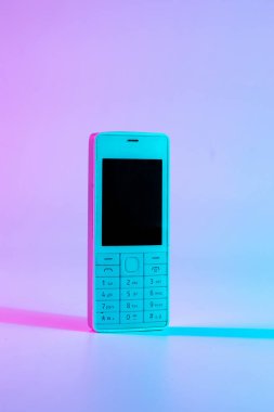 Retro dalga vintage konsepti. Pembe ışıklı, beyaz, eski bir cep telefonu. Retro dalga. Pop sanat. asgari fikir kavramı