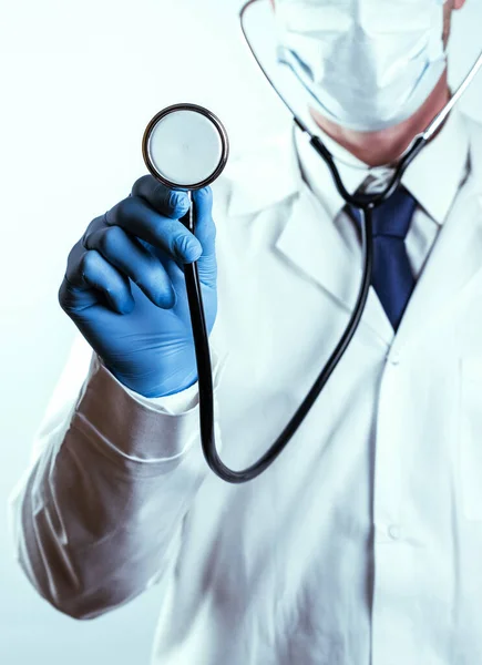 Stetoscopio mano sfondo medico. Medico felice in uniforme ospedaliera, guanti blu con stetoscopio isolato su bianco. Diagnostica, prevenzione delle malattie femminili, assistenza sanitaria. — Foto Stock