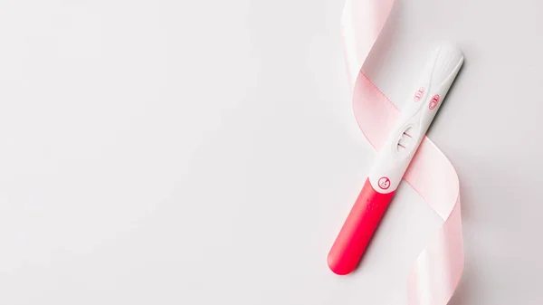 妊娠検査 白地にピンクのシルクリボンで前向き女性妊娠検査 医療保健婦人科 妊娠不妊妊産婦の概念 — ストック写真