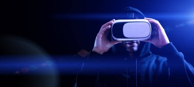 VR gözlükleri sanal gerçekliği gözlüyor. Karanlık arka planda üç boyutlu sanal gerçeklik oyunu için dijital başlıklı genç adam. 3 boyutlu simülasyonda çalışma ve sanal dünya