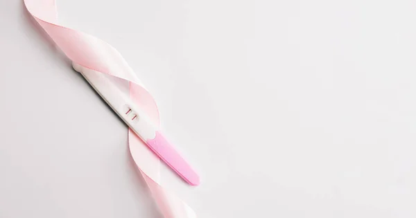 妊娠検査は隔離された 白地にピンクのシルクリボンで前向き女性妊娠検査 医療保健婦人科 妊娠不妊妊産婦の概念 — ストック写真