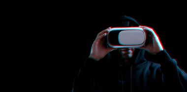 VR gözlükleri sanal gerçekliği maviye boyadı. Karanlık arka planda üç boyutlu sanal gerçeklik oyunu için dijital başlıklı genç adam. Hata efektli üç boyutlu simülasyonda çalışma ve sanal dünya