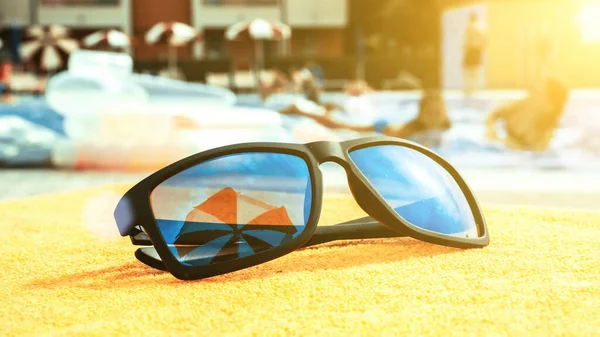 방학때는 선글라스가 수건에 선글라스쓴 바다에서의 — 스톡 사진