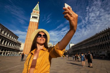 Medya Venedik İtalya 'sını etkiler. Avrupa 'da Venezia şehrinde boyama evi. Venice San Marco Meydanı 'nda akıllı telefonlu gezgin fotoğrafçı kız. Özgürlük, yaz seyahati, meslek kavramı