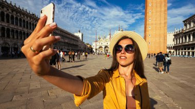 Seyahat etmenleri Venedik adasını etkiliyor. Avrupa 'da Venezia şehrinde boyama evi. Venice San Marco Meydanı 'nda akıllı telefonlu blogcu kız. Seyahat ve serbest çalışma, modern yaşam tarzı.