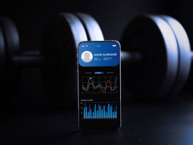 Spor salonu başvurusu. Sağlıklı akıllı telefon ekranı ya da siyah halterli spor salonu mobil uygulaması. Çevrimiçi fitness programı