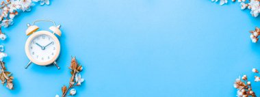 Bahar çiçeği. Çiçekler ve çiçeklerin mavi arka planda çalar saati olsun. Yumuşak odaklı, çiçek açan kayısı makrosu dalları. Kopya alanı olan Paskalya tebrik kartları için. İlkbahar