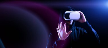 VR gözlükleri sanal gerçekliği gözlüyor. Karanlık arka planda üç boyutlu sanal gerçeklik oyunu için dijital başlıklı genç adam. 3 boyutlu simülasyonda çalışma ve sanal dünya