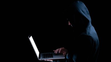 Bilgisayar korsanı siber güvenlik. Bilgisayar korsanının elindeki dijital dizüstü bilgisayar siyah pankartta izole edilmiş. İnternet hackleme teknolojisi. Veri koruması, güvenli internet erişimi, siber güvenlik