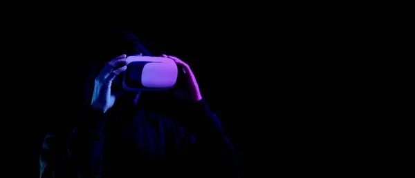 Virtuální realita vr. Mladý muž v digitálních brýlích pro technologii virtuální reality izolovaný na tmavém neonovém pozadí. Studium a virtuální svět v 3D simulaci. — Stock fotografie