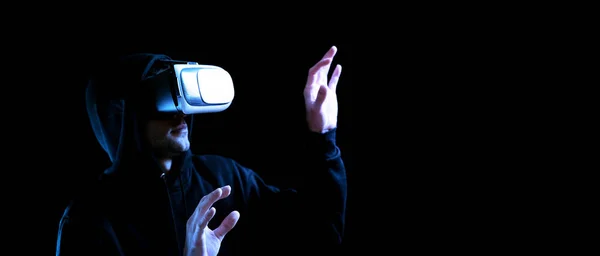 Vr gafas de realidad virtual. Hombre joven en casco digital para 3d juego de realidad virtual sobre fondo oscuro. Estudio y mundo virtual en simulación 3D. — Foto de Stock