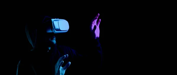 Jeu de réalité virtuelle vr. Jeune homme en lunettes numériques pour la technologie de réalité virtuelle isolé sur fond néon foncé. Etude et monde virtuel en simulation 3D. — Photo