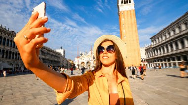 Blogcu kız Venedik. Venice San Marco Meydanı 'nda akıllı telefonlu gezgin fotoğrafçı kadın. Avrupa 'da Venezia şehrinde boyama evi. Serbest çalışan, gazeteci, profesyonel fotoğrafçı.