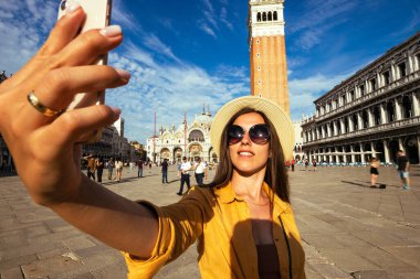 Seyahat etmenleri Venedik adasını etkiliyor. Avrupa 'da Venezia şehrinde boyama evi. Venice San Marco Meydanı 'nda akıllı telefonlu blogcu kız. Seyahat ve serbest çalışma, modern yaşam tarzı.