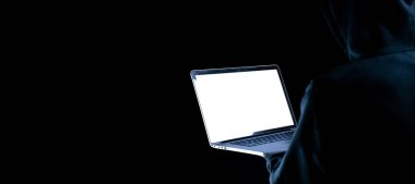 Siber güvenlik korsanı konsepti. İnternet hackleme teknolojisi. Bilgisayar korsanının elindeki dijital dizüstü bilgisayar siyah pankartta izole edilmiş. Veri koruması, güvenli internet erişimi, siber güvenlik