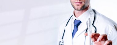 Şırınga iğnesi tıbbi enjeksiyon. Seçici odaklanma, doktorun elinde şırıngayla mavi eldiven tutması. Hastane beyaz doktor önlüğü, steteskop. Kopya alanı olan grip aşısı şırıngası