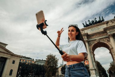 Gezginler Milan adasını etkiliyor. Avrupa 'da boyama evi Milano' da. Piazza del Duomo, Katedral Meydanı 'nda akıllı telefonlu fotoğrafçı kız. Seyahat ve serbest çalışma, modern yaşam tarzı.