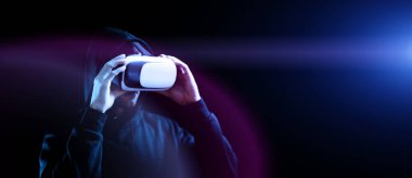 VR gözlükleri sanal gerçekliği gözlüyor. Karanlık arka planda üç boyutlu sanal gerçeklik oyunu için dijital başlıklı genç adam. 3 boyutlu simülasyonda çalışma ve sanal dünya