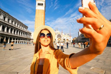 Blogcu kız Venedik. Venice San Marco Meydanı 'nda akıllı telefonlu gezgin fotoğrafçı kadın. Avrupa 'da Venezia şehrinde boyama evi. Serbest çalışan, gazeteci, profesyonel fotoğrafçı.