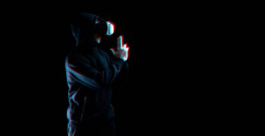 Sanal gerçeklik gözlükleri. Sanal gerçeklik teknolojisi için dijital kulaklık takmış, karanlık arka planda hatalı bir genç adam. İnanılmaz teknoloji, çevrimiçi oyun, eğlence