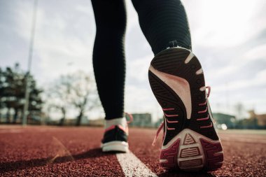 Spor koşucusu kız eğitimi. Kadın egzersizi yap. Koşan ayaklar yolda, ayakkabıya yakın gidiyor. Fitness, spor, yaşam tarzı konsepti