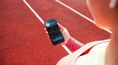 Sağlık uygulaması. Spor salonu ya da spor salonu mobil uygulaması olan akıllı telefon ekranı. Evde tutulan kadın çevrimiçi egzersiz uygulaması