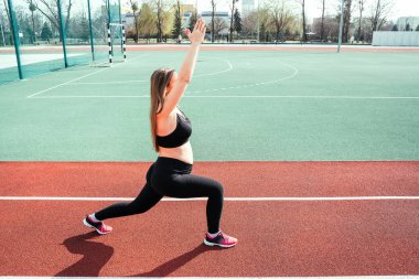 Hamilelik eğitimi. Hamile kadın yoga sporu antrenmanı yapıyor. Dışarıda doğum öncesi sağlıklı spor salonu var. Doğum öncesi egzersizleri.